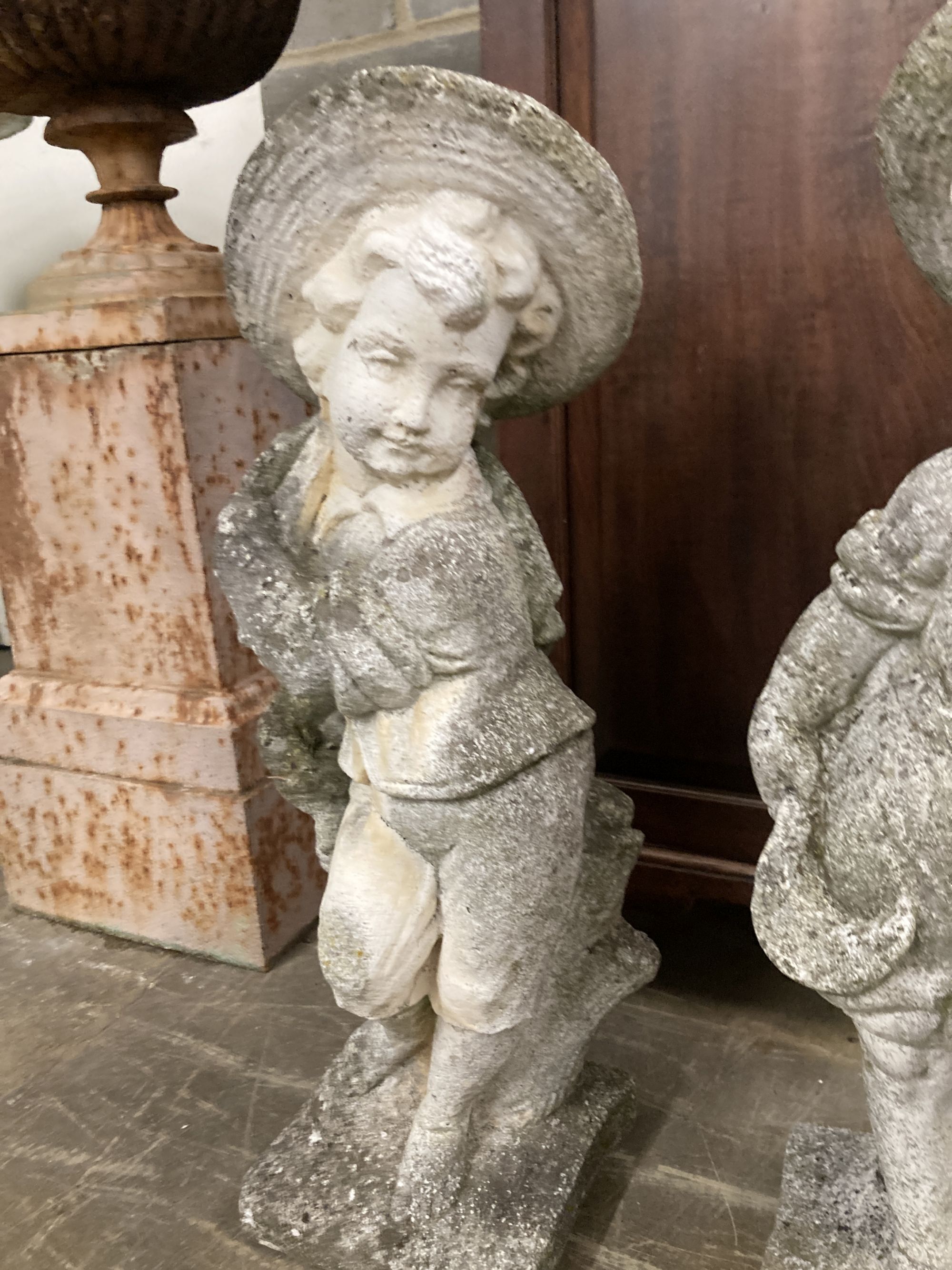 A pair of reconstituted stone garden ornaments, boys with wheatsheaves, larger 87cm high